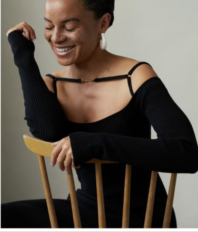 Samira Rafaela, lachend op een houten stoel